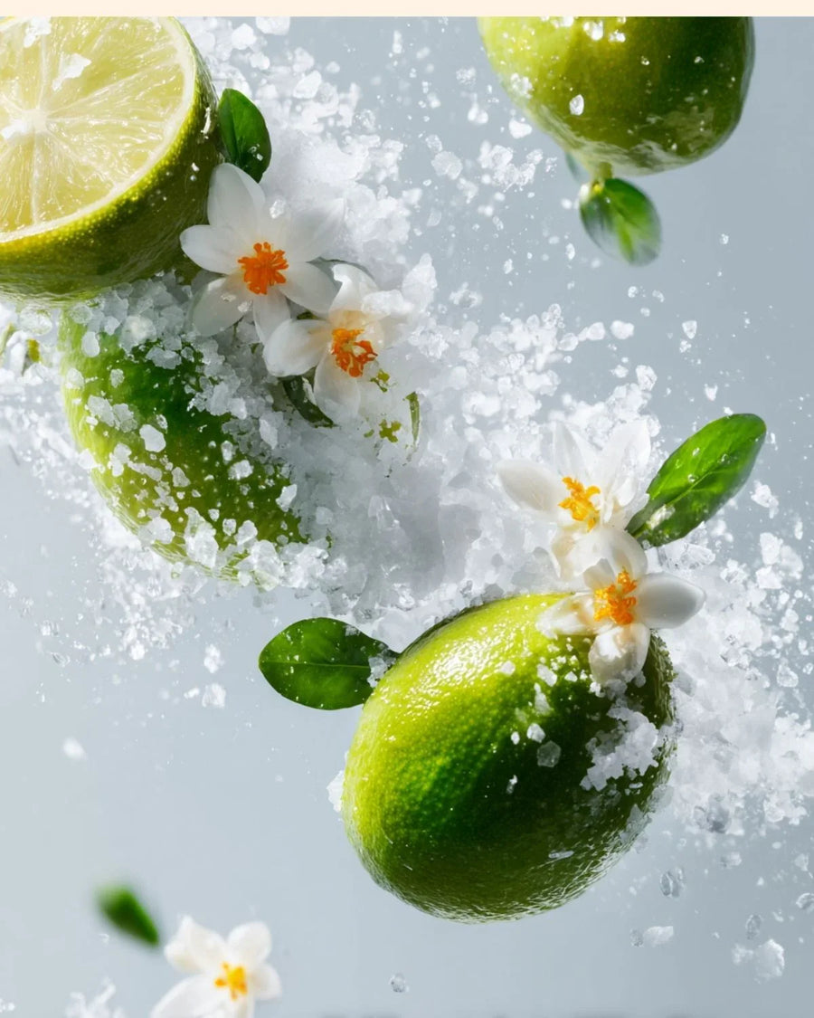 Fresh limes, white flowers, and sea salt with fragrant oil ingredients on a light background