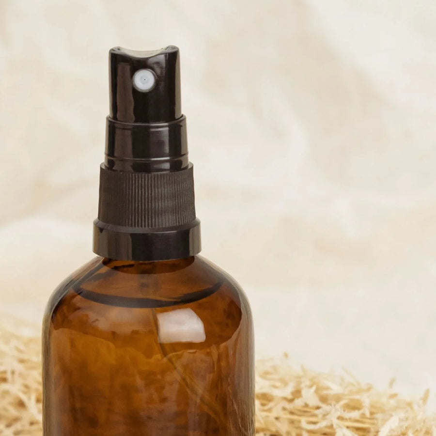 Amber glass spray bottle for fragrance oils or diffuser supplies on neutral background