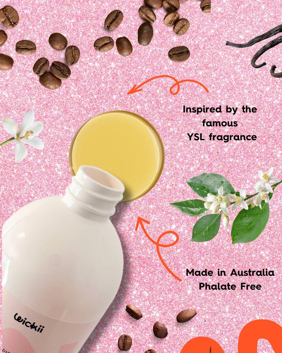 Fragrance oil bottle with spilled liquid, coffee beans, vanilla, and flowers on pink glitter background