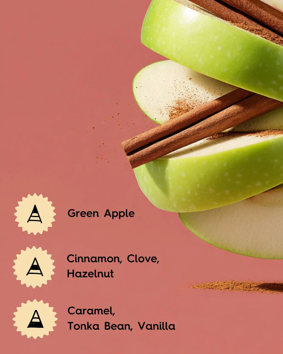 Green apple slices with cinnamon sticks, spice powder, and fragrance notes on pink background.