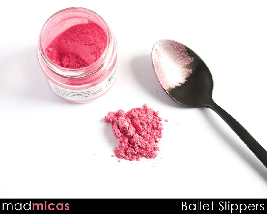 Pink mica powder labeled Ballet Slippers in a jar, with powder on a spoon and white background