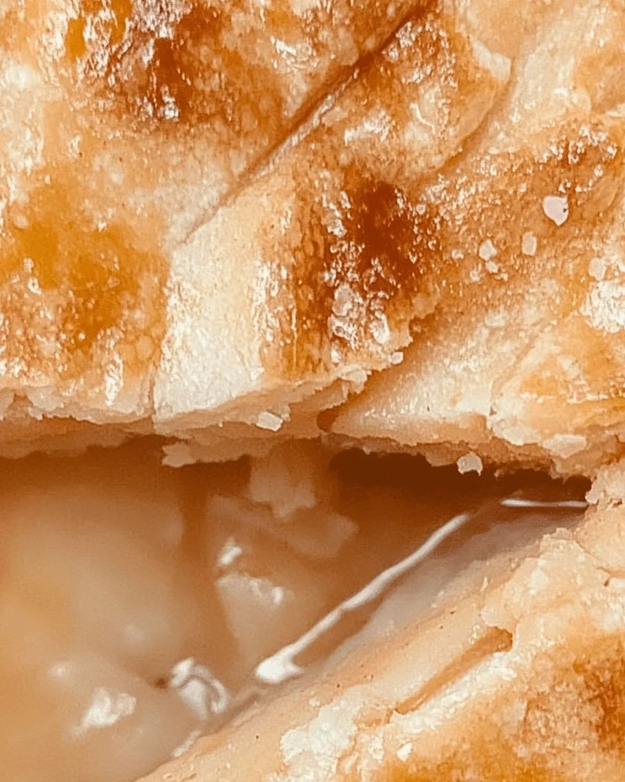 Closeup of golden baked crust with creamy filling, flaky pastry texture visible
