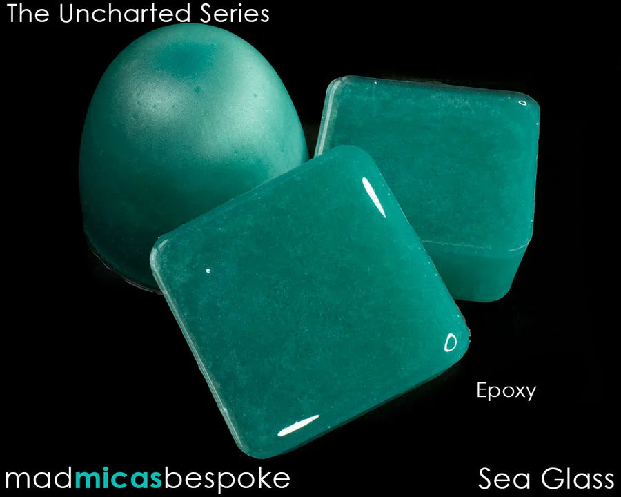 Teal sea glass colored epoxy soap bars and dome on black background, Uncharted Series.