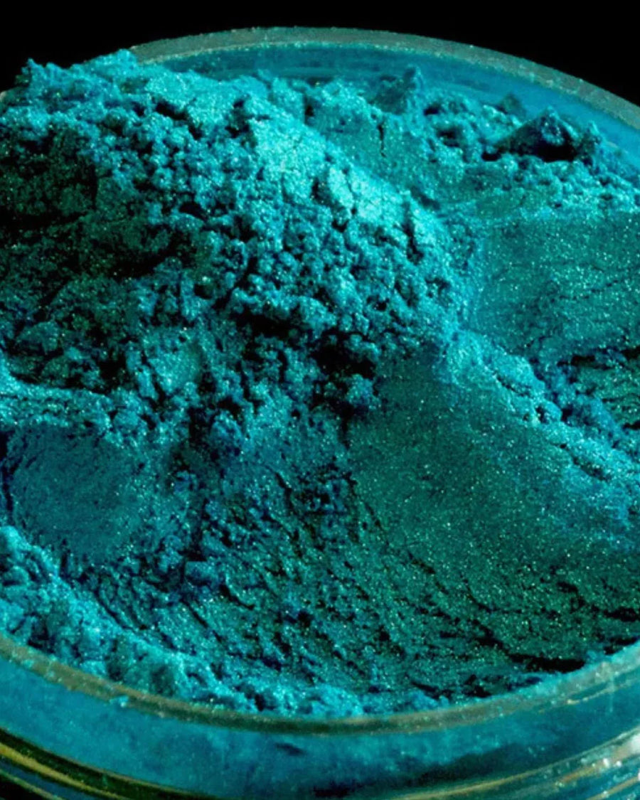 Shimmering blue mica powder pigment in a clear container for candle or soap making supplies