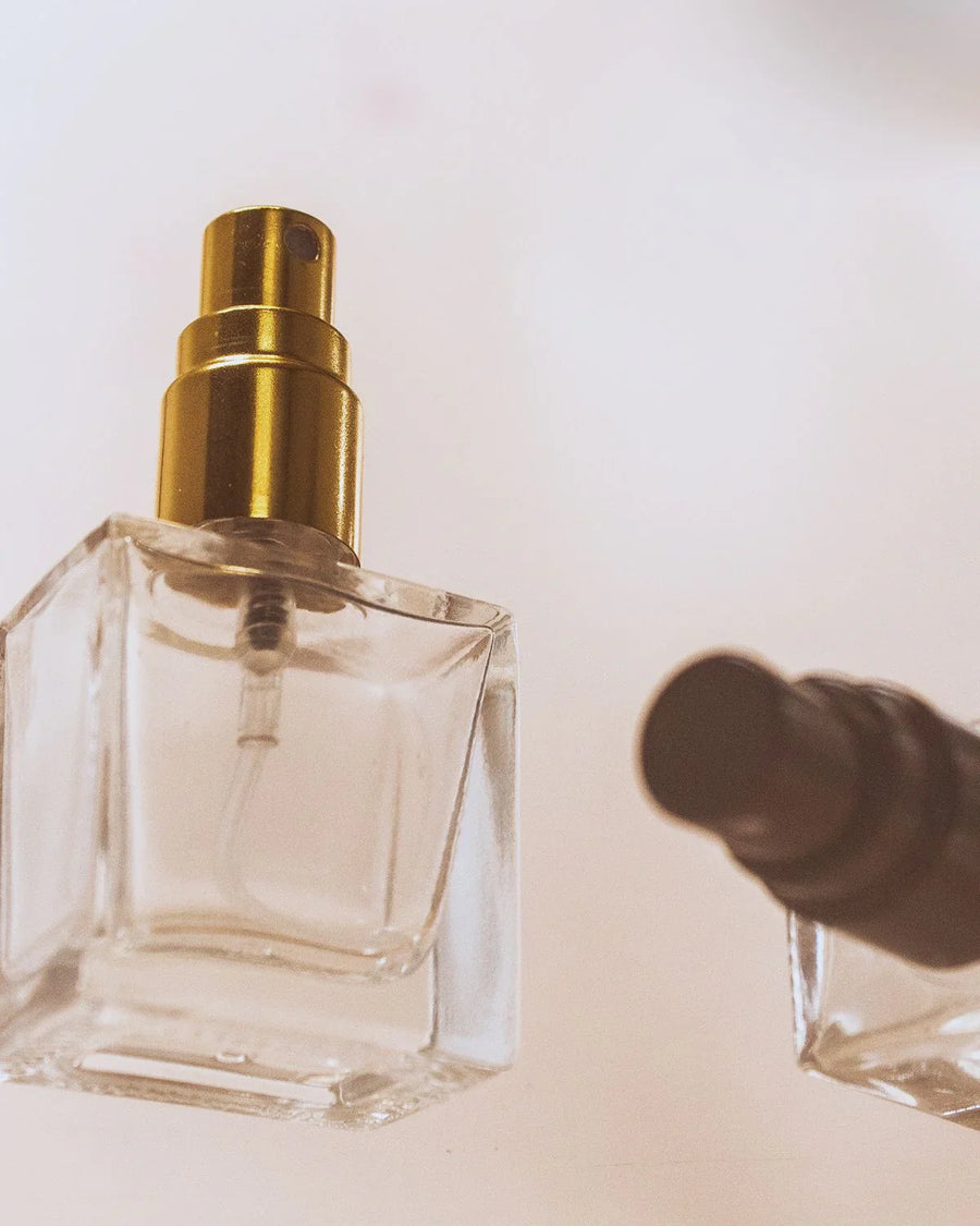 Clear rectangular 10ml glass perfume spray bottles with gold atomiser on white background