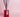 Red glass reed diffuser bottle labeled 'Musk Edit' with black reeds on a pink background