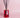 Red glass reed diffuser bottle labeled 'Musk Edit' with black reeds on a pink background