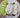 Handmade white soaps with black pepper, heart and round shapes, sliced cucumber on plate