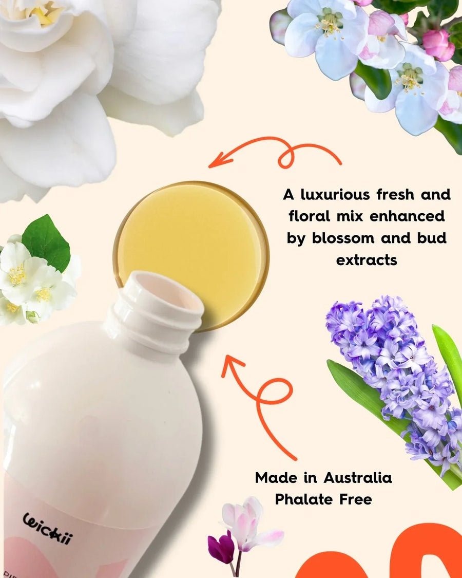 Floral fragrance oil bottle with open cap, surrounded by white and purple flower blossoms.