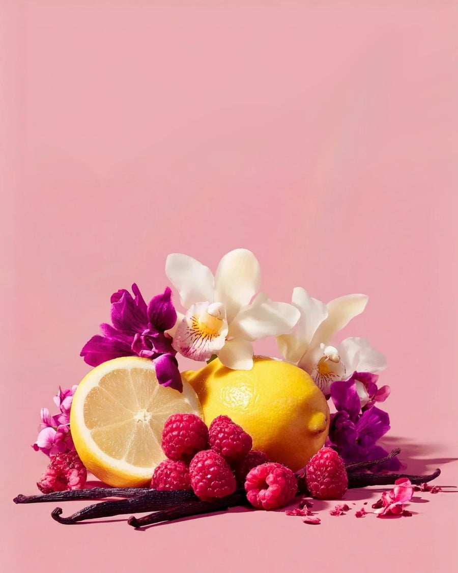 Fresh lemon, raspberries, vanilla beans, and orchids on pink background, fragrance inspiration