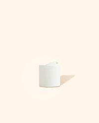 White plastic candle or diffuser bottle cap on a neutral background