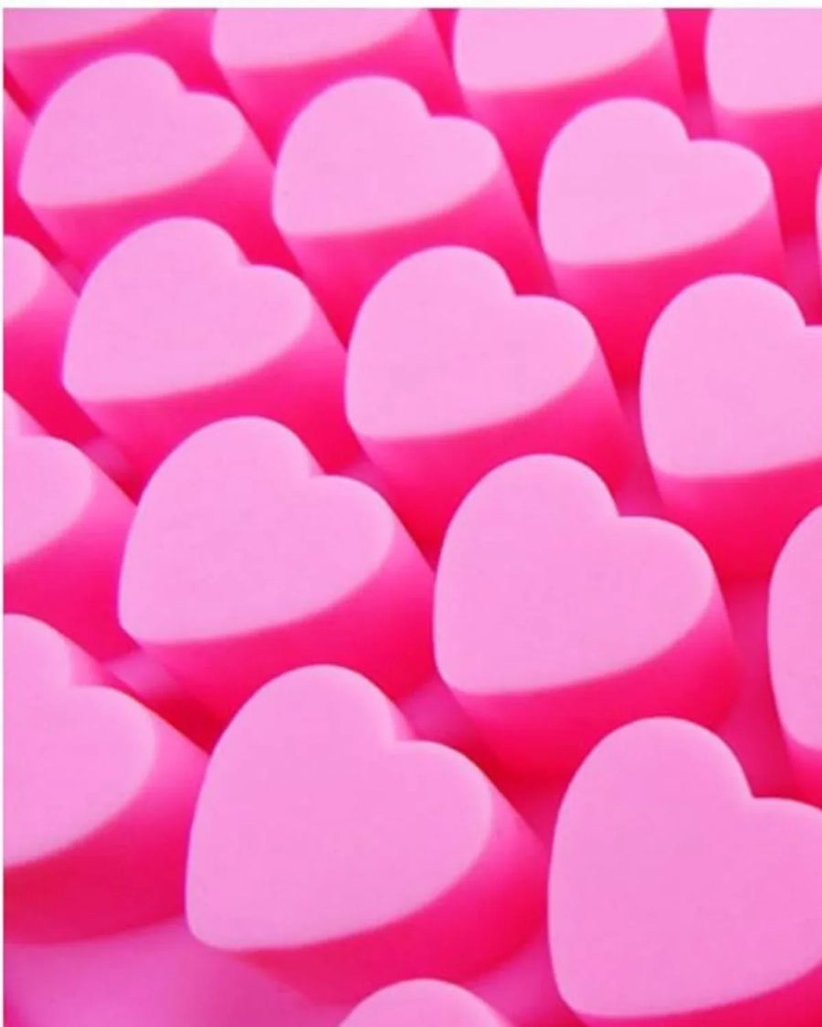 Pink heart-shaped soap bases arranged in rows for DIY soap making supplies.