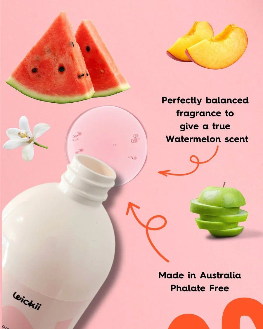 Watermelon fragrance oil bottle with watermelon, apple, peach, and floral ingredients on pink background.