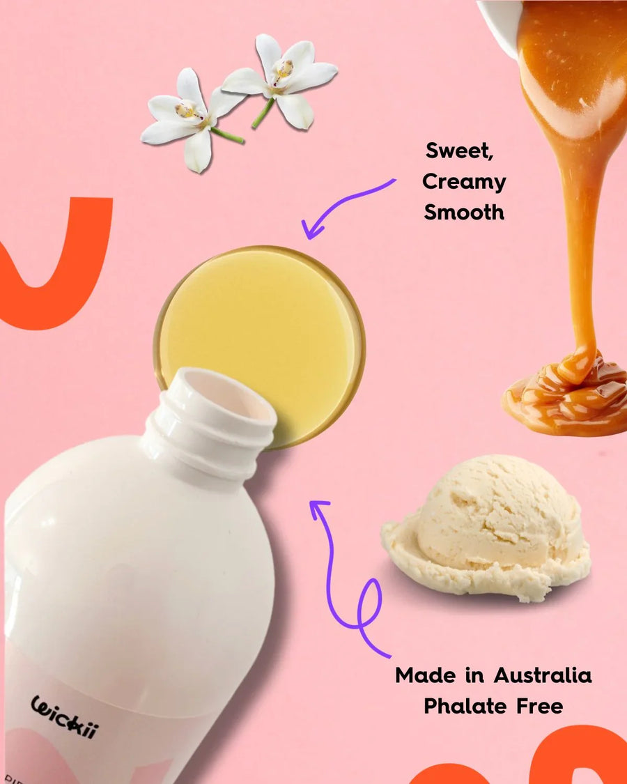 Fragrance oil bottle with creamy liquid, vanilla flowers, caramel, and ice cream on pink background