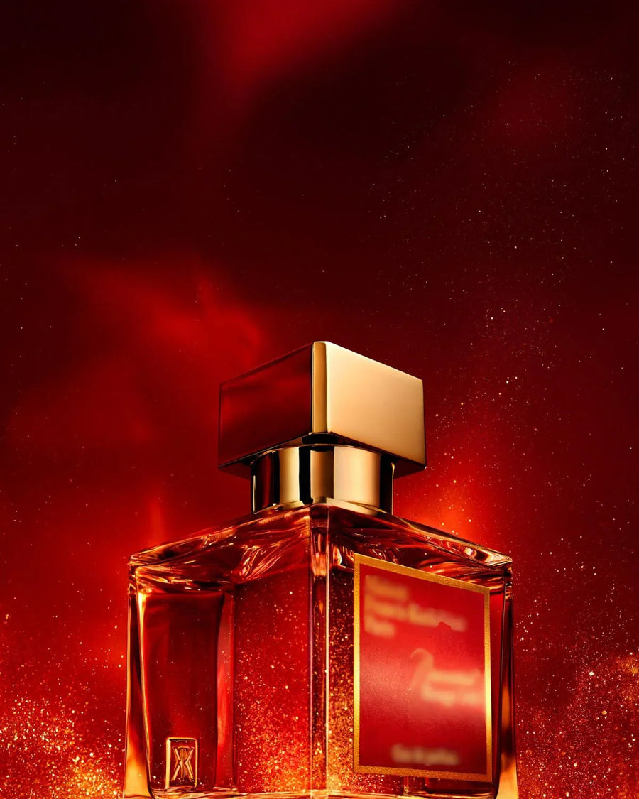 Transparent glass fragrance oil bottle with gold cap and red label on glowing red background