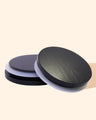 Round black candle jar lids with white silicone seal on a neutral background
