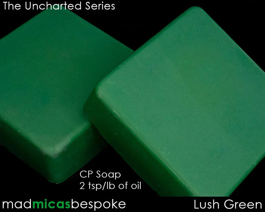 Two rectangular bars of lush green cold process soap on a black background