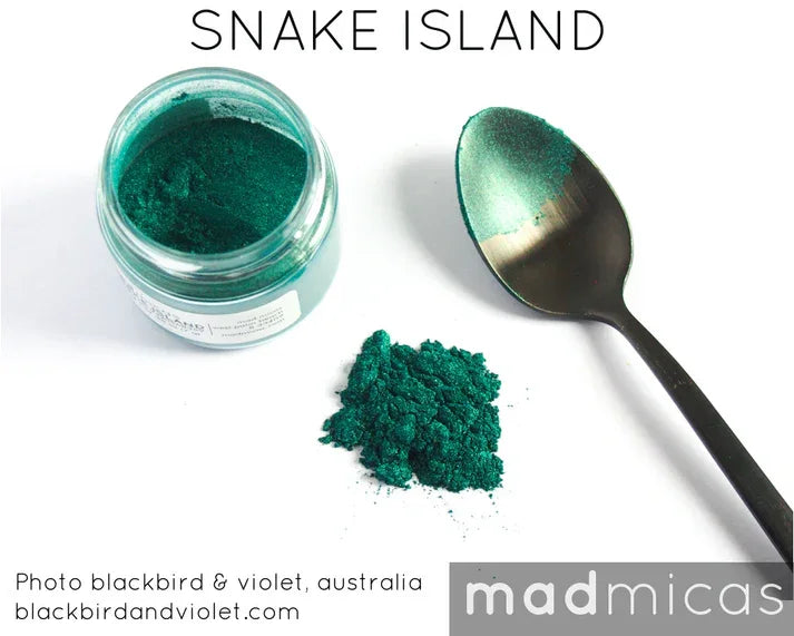 Open jar of green Snake Island mica powder with a pile and a spoonful beside it.