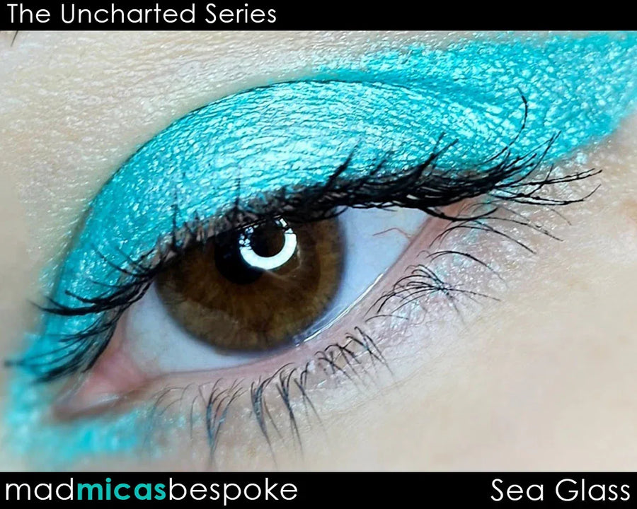 Close-up of eye with vibrant sea glass blue eyeshadow, shimmering cosmetic pigment.