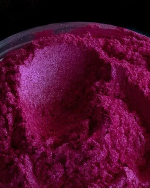 Bright magenta mica powder for candle making and soap crafting in a clear container
