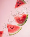 Fresh watermelon slices with water splashes on a pink background