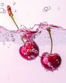 Fresh cherries splashing in water with bubbles, fruity fragrance inspiration