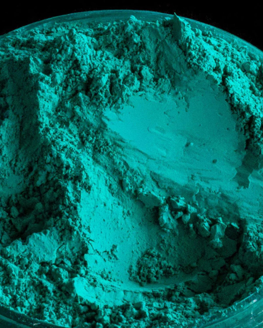 Close-up of teal green mica powder in a container for candle or soap making supplies