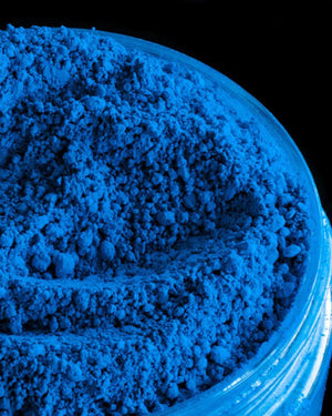 Bright blue pigment powder in a clear plastic jar for candle and soap making supplies