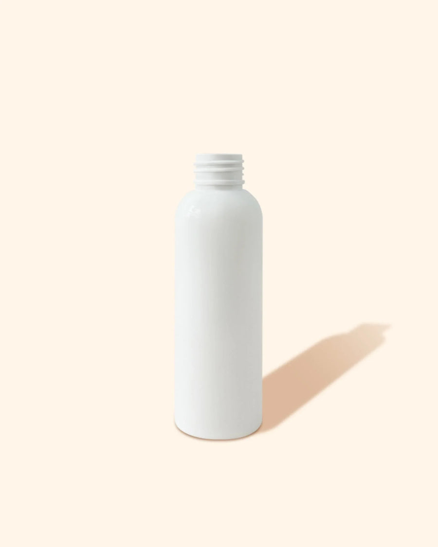 Empty white plastic bottle for candle making supplies on a beige background