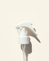 White mini trigger spray nozzle for bottles on a light background, ideal for diffusers.